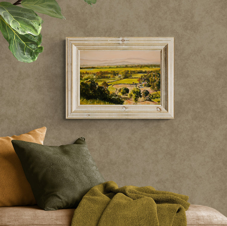 Impressionistic landscape painting of rolling green fields with distant misty mountains. Serene countryside scenery with lush trees and soft golden light. Perfect fine art print for nature lovers and home decor.