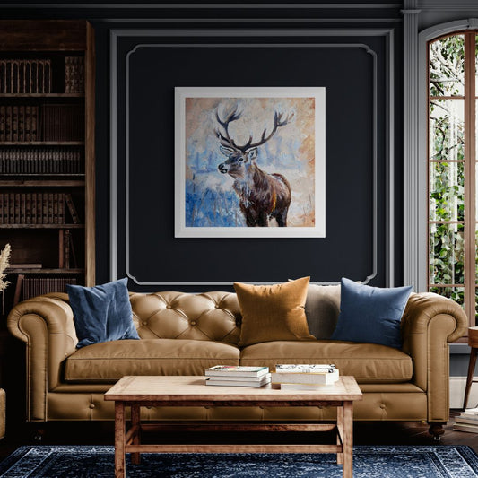 Echoes of the Wild Stag Fine Art Print in White frame in sitting room with dark wall and leather sofa.