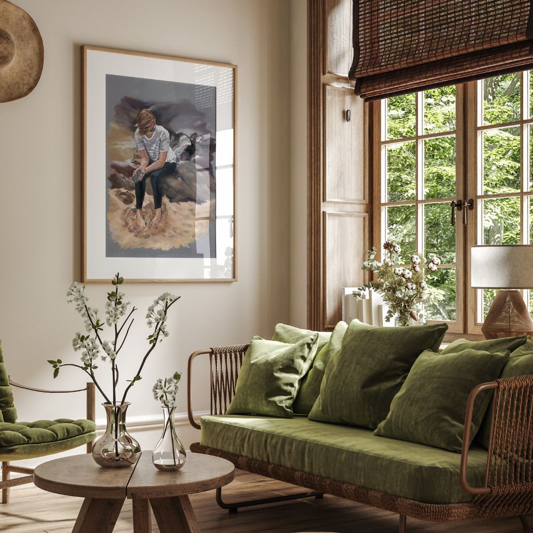 Living room with green sofa, wicker chair, and framed artwork of girl on beach holding phone and looking wistfully into the sand.