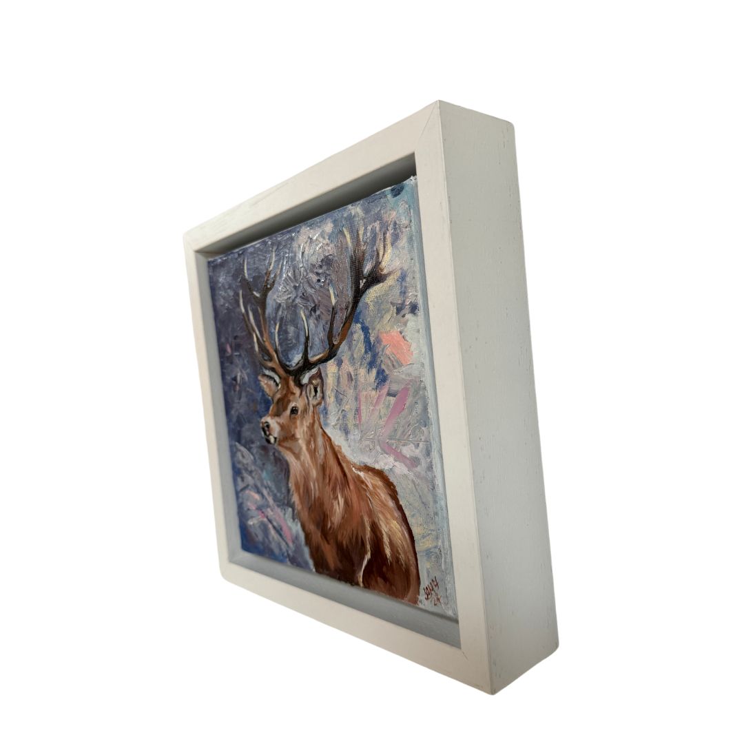 Framed oil painting showcasing a noble stag with detailed antlers, standing against a semi-abstract blue, white, and pink gradient background. A beautiful addition to nature-inspired art collections.