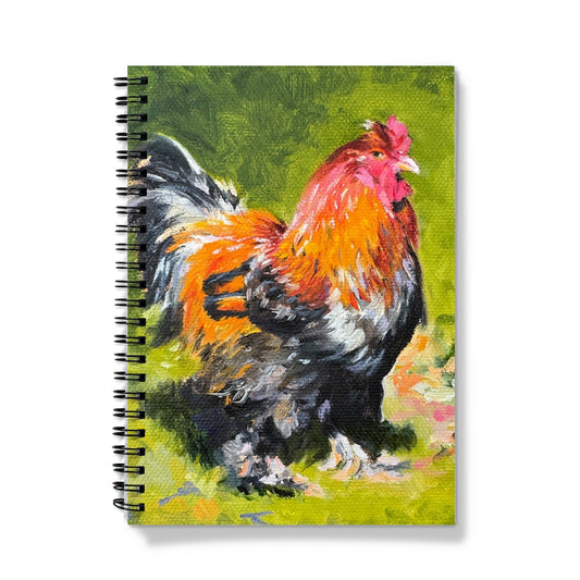 A notebook with a spiral binding featuring an artistic depiction of a cockerel with a mix of green, black, and orange colors on the cover.