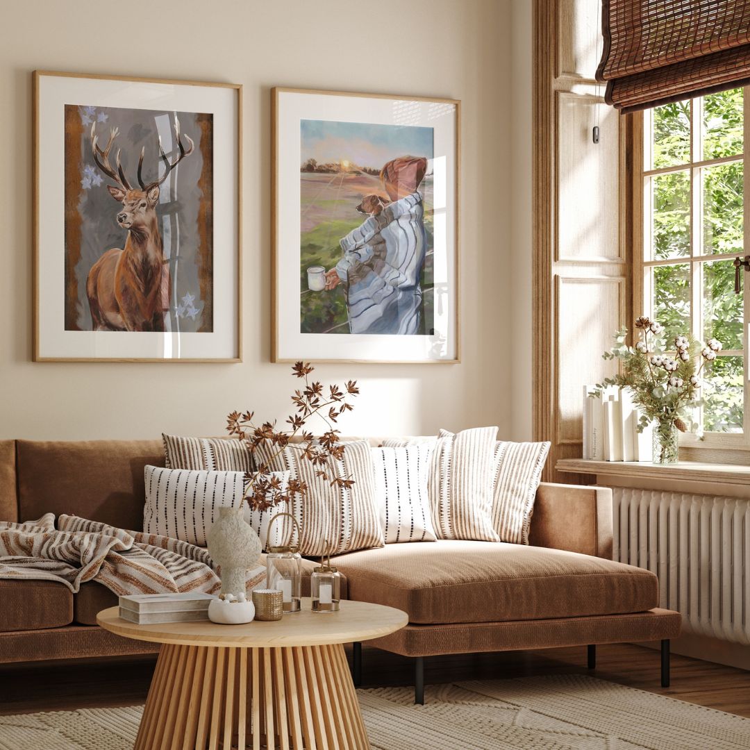 Living room with brown sectional sofa, round wooden coffee table, and framed deer and dog artwork on the wall.