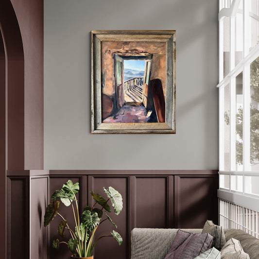 Framed Mediterranean oil painting displayed in a warm neutral living room interior.