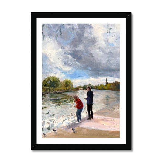 Swans in Stratford fine art print in elegant black frame, showing figures feeding swans beside the River Avon in Stratford-upon-Avon.