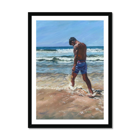 Emotional coastal fine art print of a solitary man walking through surf on a Cornwall beach, presented in a black frame. Moody seaside wall art for contemporary interiors.
