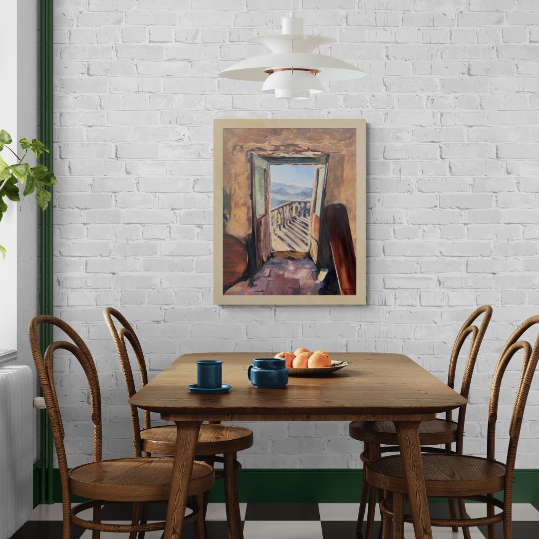 A Italian doorway canvas art print by Lorraine Field Art displayed on white painted brick wall, above wooden table and chairs next to a window