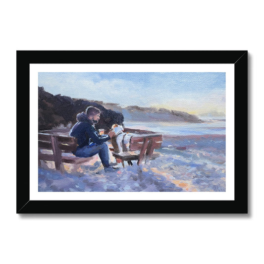 A man and his dog enjoy sunset together on a bench on a beech. 