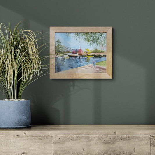 Original oil painting of a young girl beside the River Avon at Bridge Foot in Stratford-upon-Avon, displayed in a modern interior setting by Lorraine Field Art.