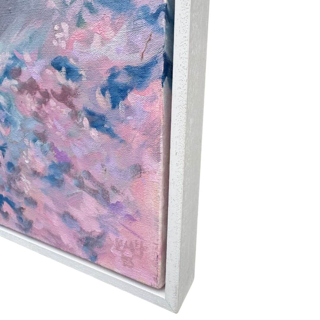 Close-up of pink floral brushwork and the lower corner of the pale wooden float frame surrounding the original oil painting.