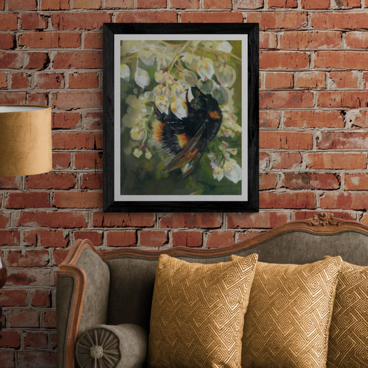 Bumble Bee Wall Art in black frame on brick wall above green sofa. 