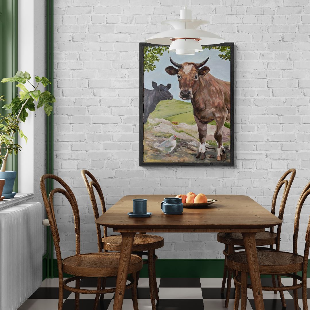 Two cows and their chicken friend in a cow art print displayed above a kitchen table.