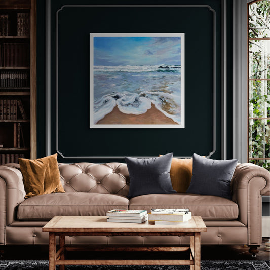 Frothy seas art print in white frame option on dark blue wass above beige sofa
