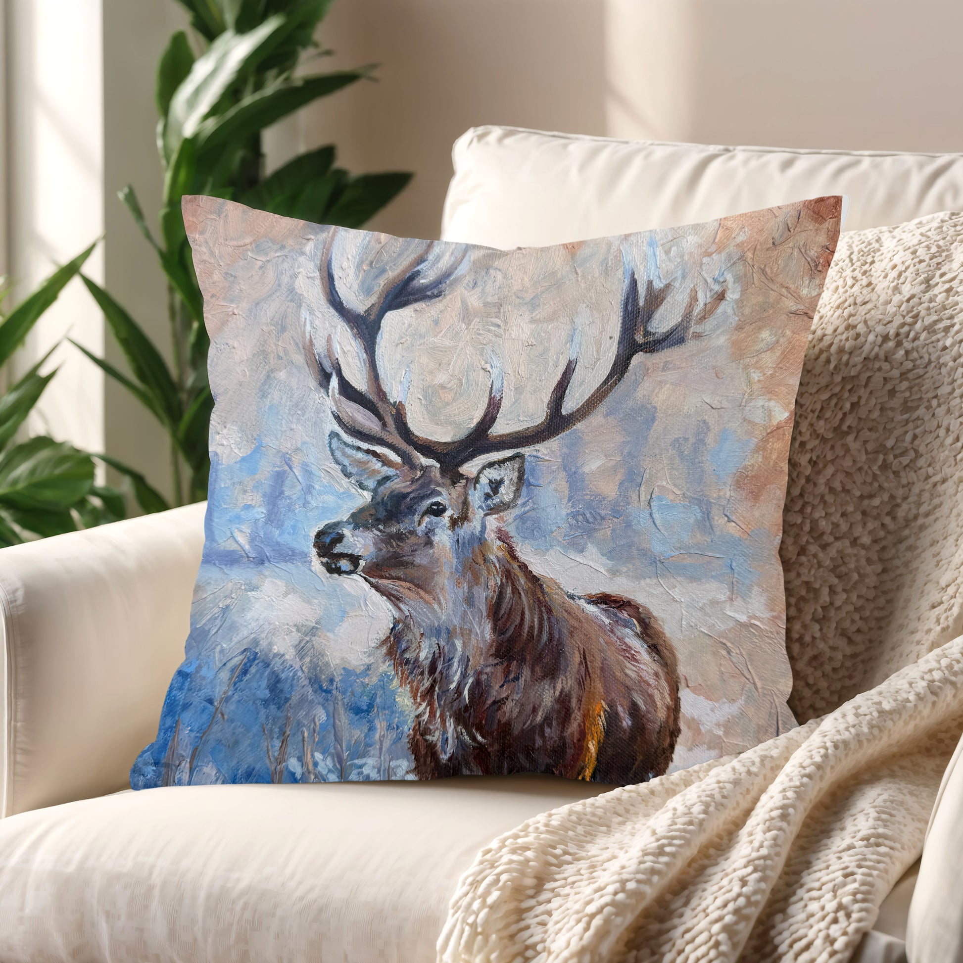 Echoes of the Wild stag cushion styled on a neutral sofa – adds warmth and quiet strength to your space.