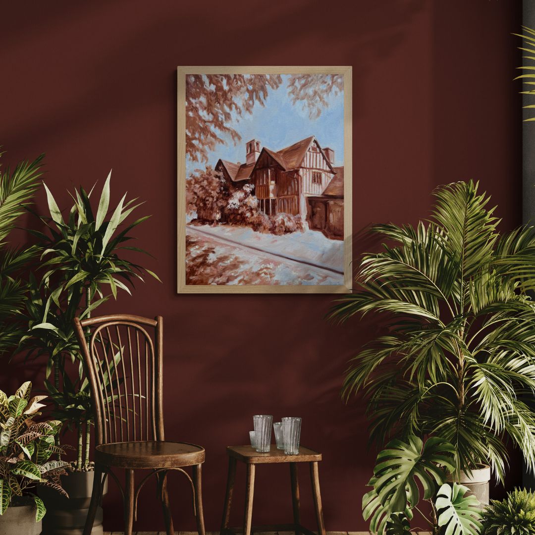 Hall’s Croft fine art print displayed in a natural wood frame on a deep rich red wall, styled with wooden furniture and lush green plants for a cosy, heritage-inspired home.