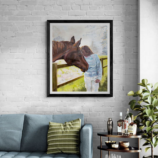 Framed art print in black frame option of a person and horse holding their heads together, displayed on a white brick wall above a sofa.