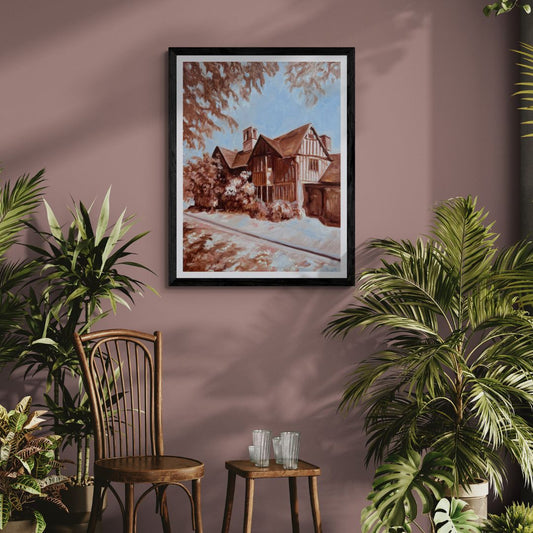 Hall’s Croft fine art print in a black frame displayed on a dusky pink wall with plants and vintage wooden chairs, inspired by Shakespeare’s daughter’s historic Stratford-upon-Avon home.