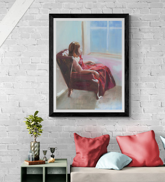 Lady in red dress sitting in red leather armchair gazes out window 