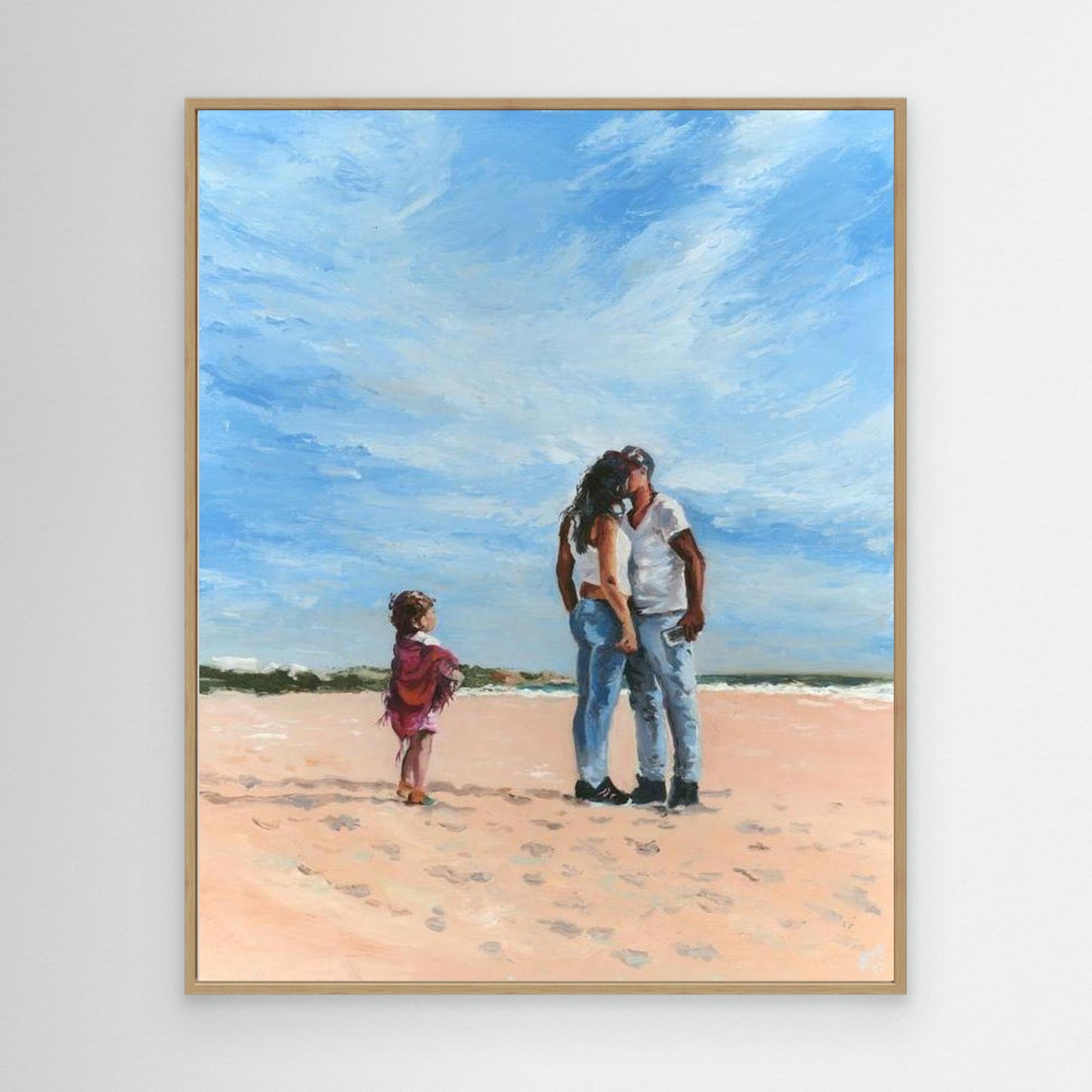 'Mama' canvas print in an oak frame, showing a couple embracing on a beach while a child stands nearby, full of story and intrigue.