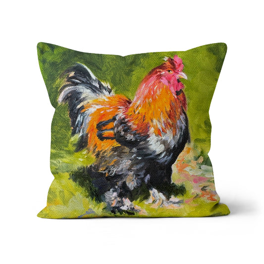 A cushion with an image of a colorful cockerel displayed against a green background.