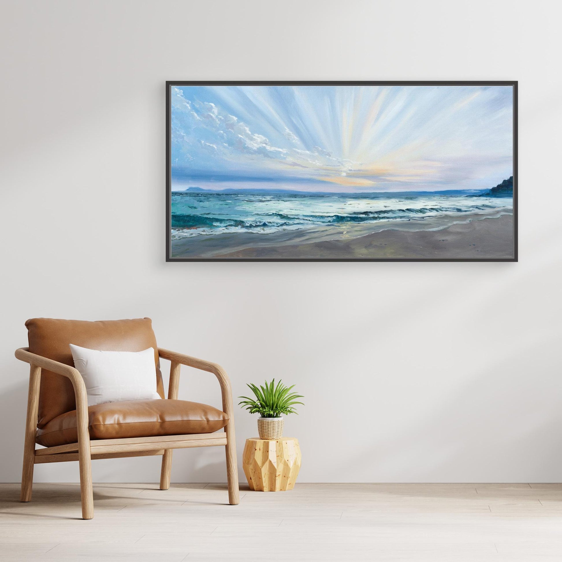 Large panoramic beach canvas artwork displayed above a chair in a calm neutral interior inspired by Cornwall’s coastline.