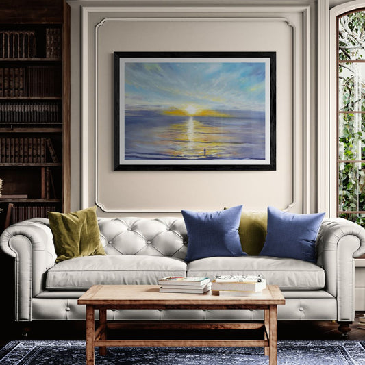 Living room with a gray sofa, wooden coffee table, and framed seascape artwork of a sunrise at Penzance seafront.
