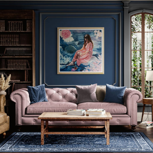 Pink sofa in a living room with a sentimental figurative painting on the wall and a coffee table in front.
