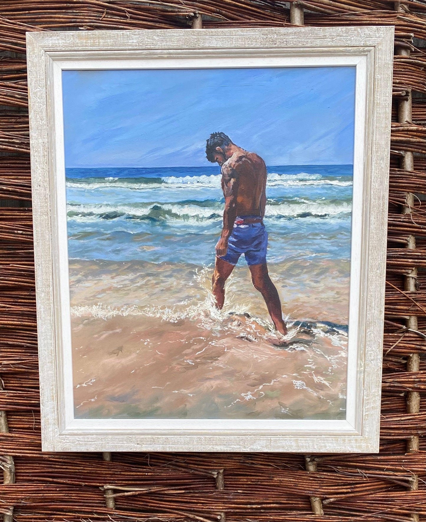 Seascape painting with young man kicking surf