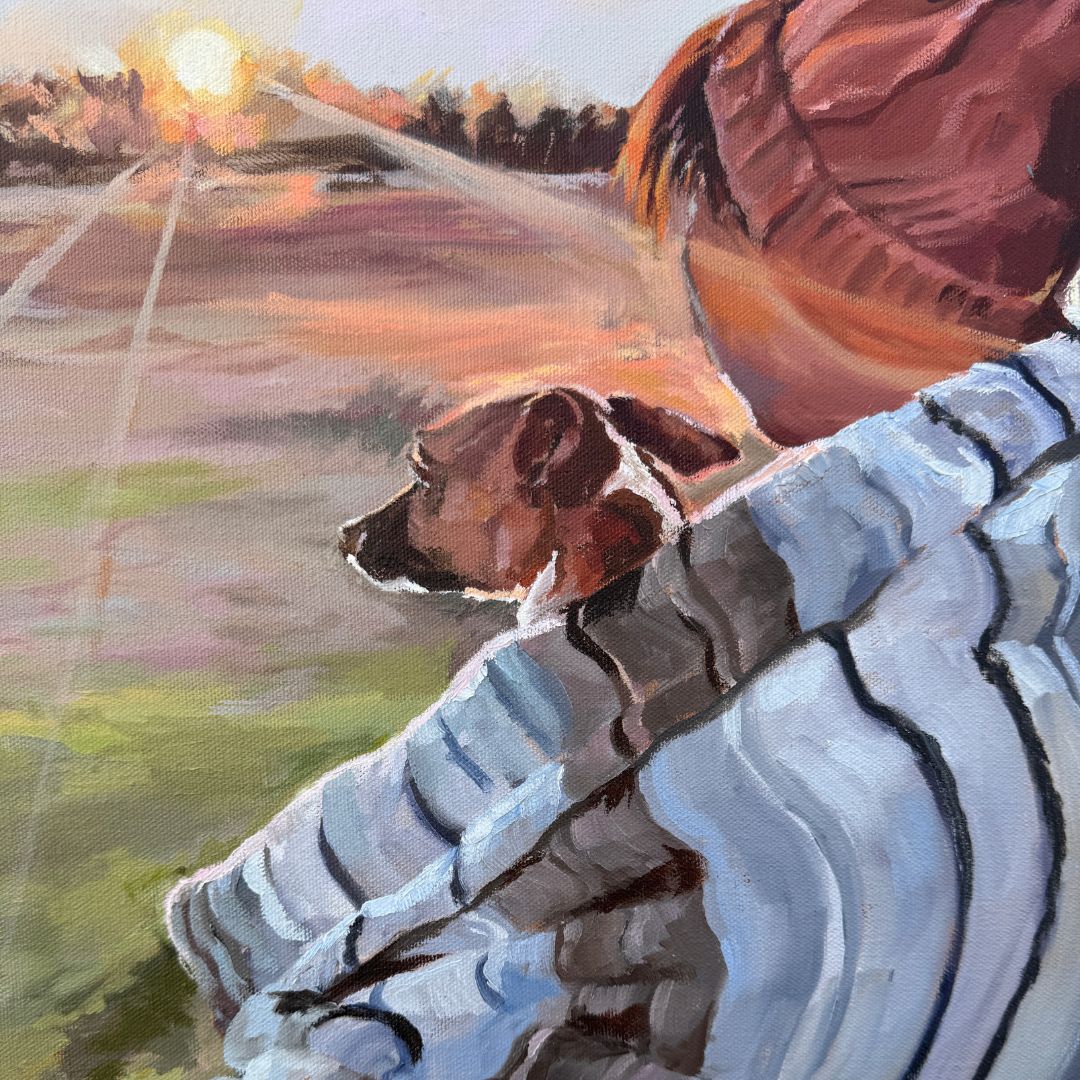 Person and Jack Russell dog watching a sunset across a country field