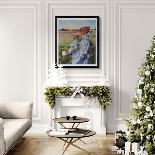 Living room with Christmas tree, fireplace, and wall art fine art print of lady with a dog wrapped in a blanket and a mug in her hand.