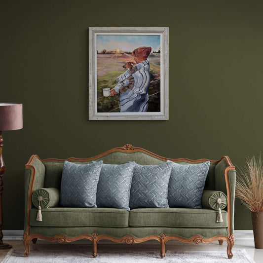 Framed oil painting of a person with a Jack Russell dog on a dark green wall above a green sofa with patterned cushions and pink lamp