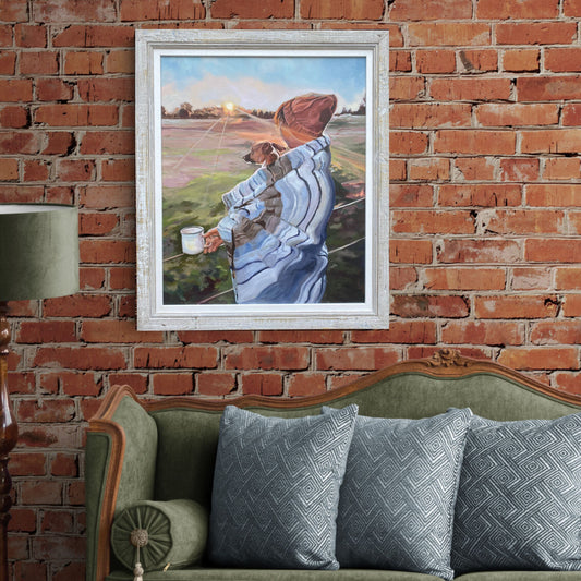 Framed oil painting of a person with a Jack Russell dog on a brick wall above a green sofa with patterned cushions.