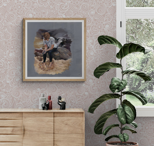 Young woman sitting barefoot beside the sea holding a mobile phone. Emotional contemporary fine art print in wood frame option exploring silence, longing, and modern connection.