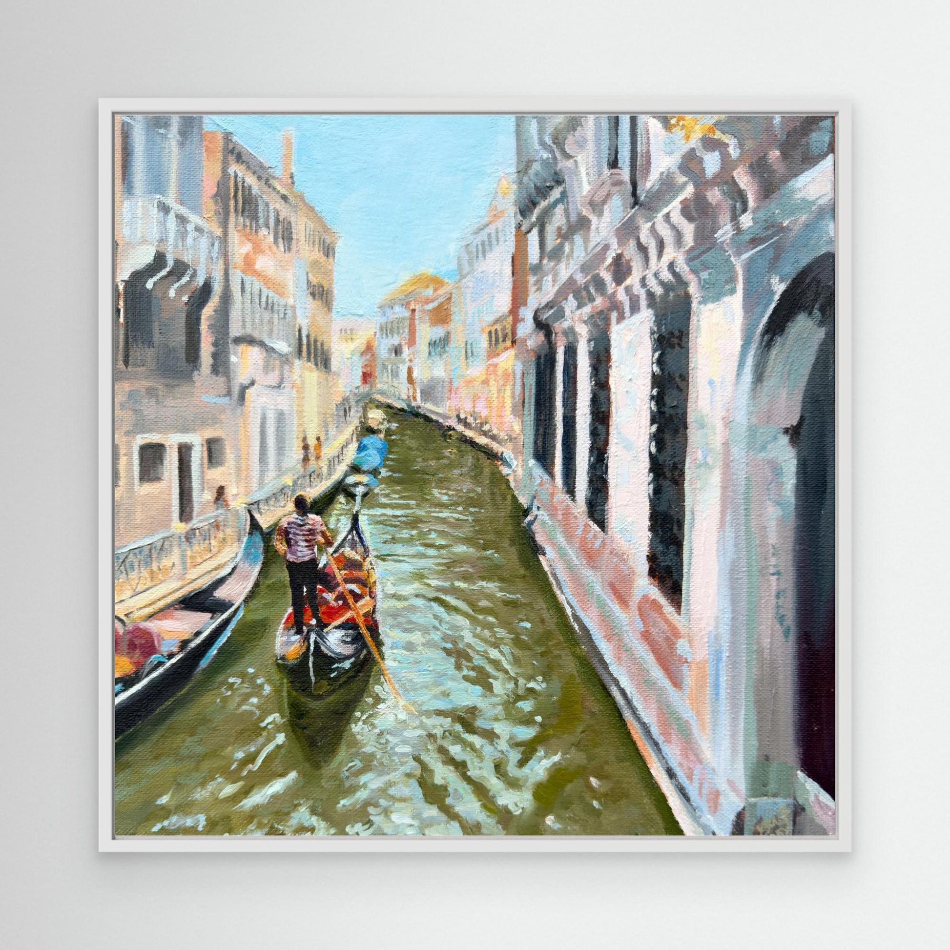 Framed artwork of a  Venice with a gondola on a canal with buildings on either side.