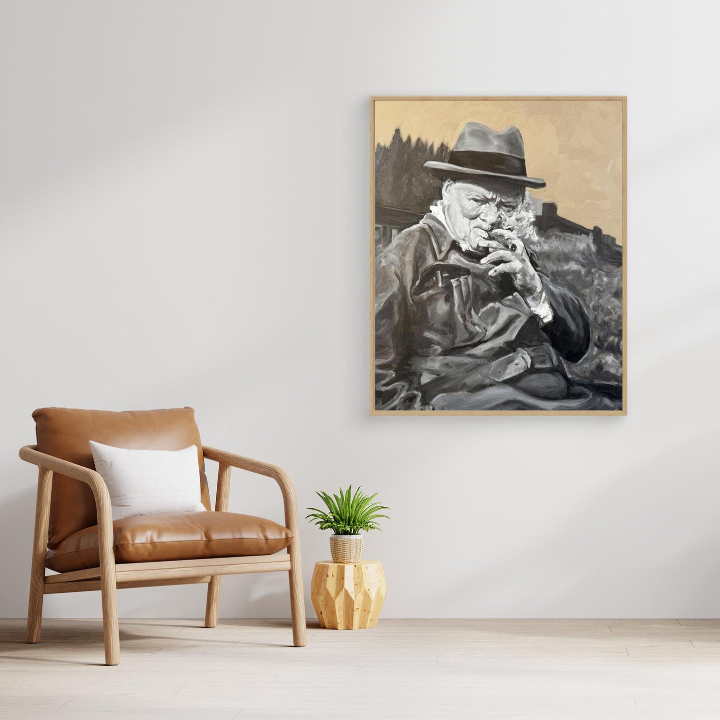 Oak framed Winston Churchill portrait canvas print placed beside a chair in a warm, contemporary interior with natural textures