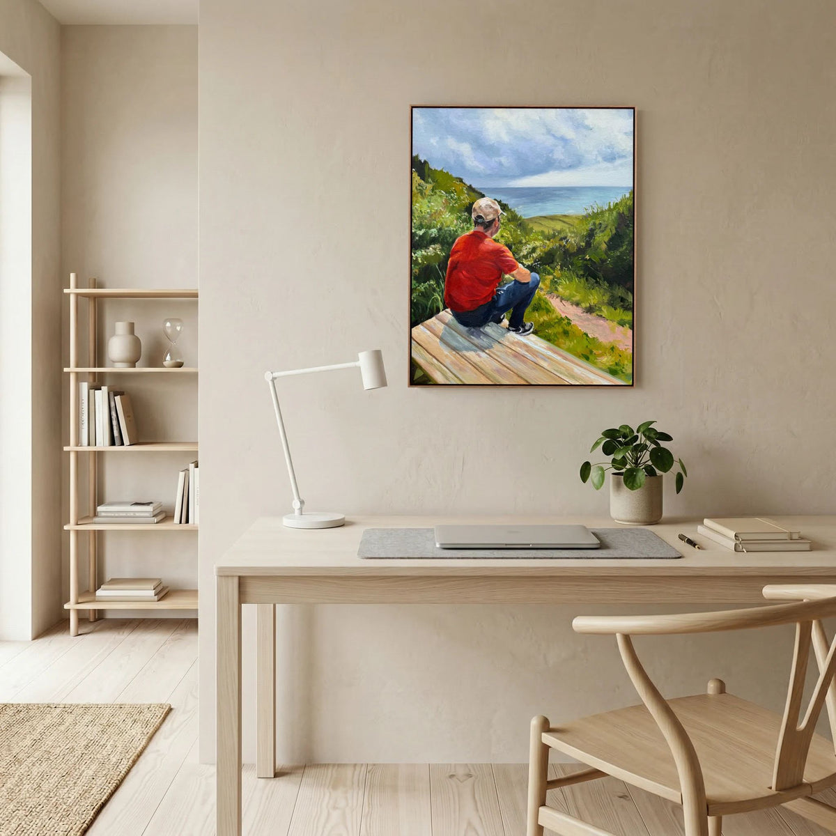 Just taking it in canvas print by Lorraine Field, showing a person in red seated on a bench overlooking countryside, displayed above a desk.