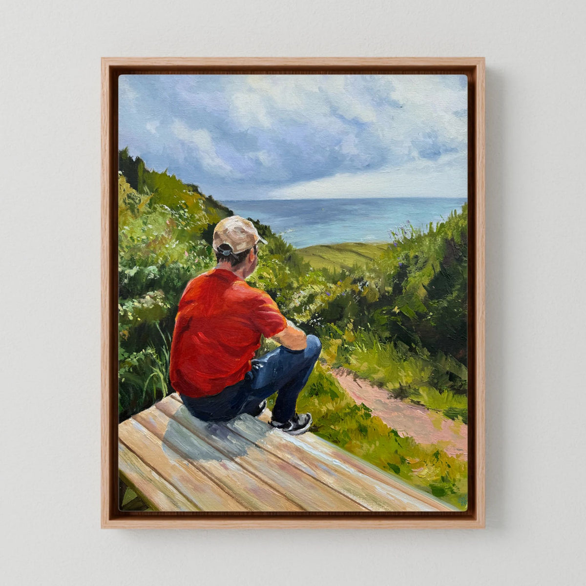Just taking it in canvas print by Lorraine Field in an oak frame, showing a person in red on a wooden bench overlooking green hills.