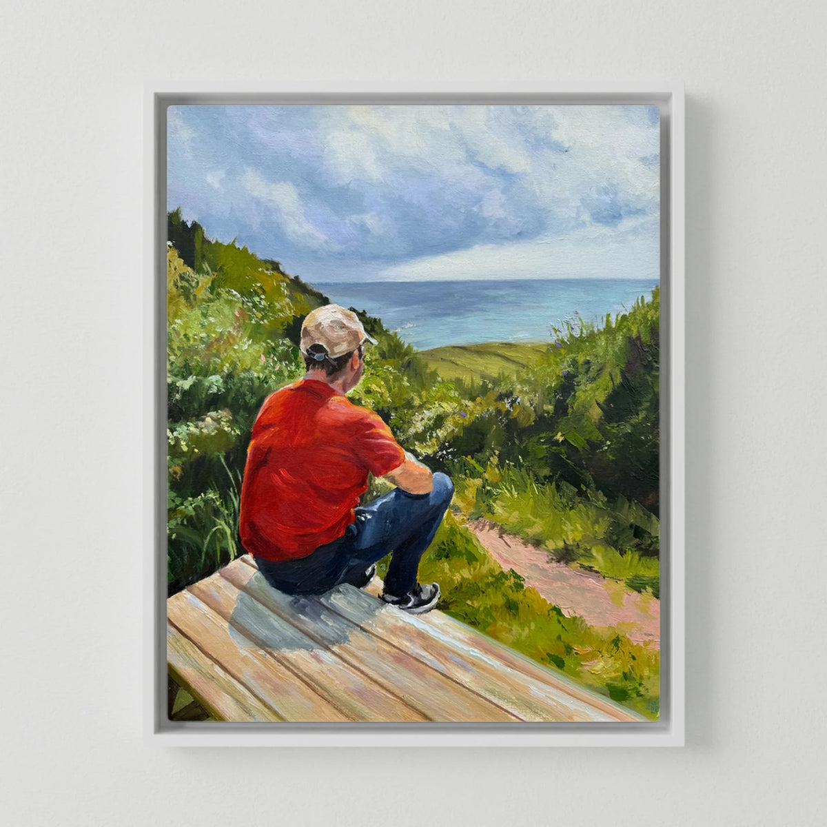 Just taking it in canvas print in a white frame, depicting a person seated on a bench beneath a blue sky with white clouds.