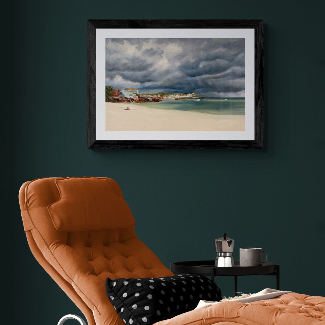 Porthminster Picnic fine art print in black frame displayed above chair in modern living room