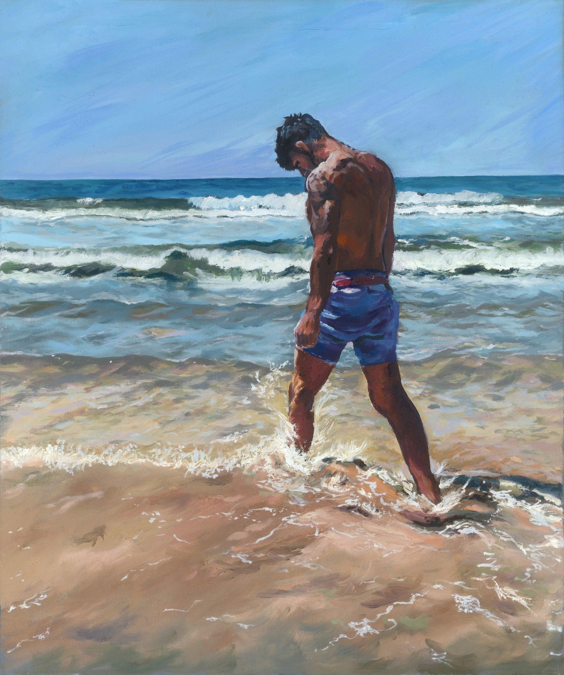 Young man kicking surf in deep blue sea